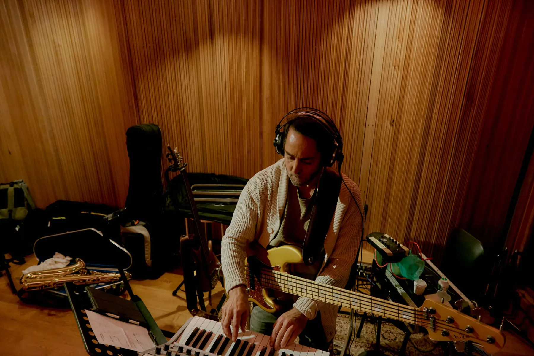 A musician tracking bass and keys on the live room floor at A Sharp