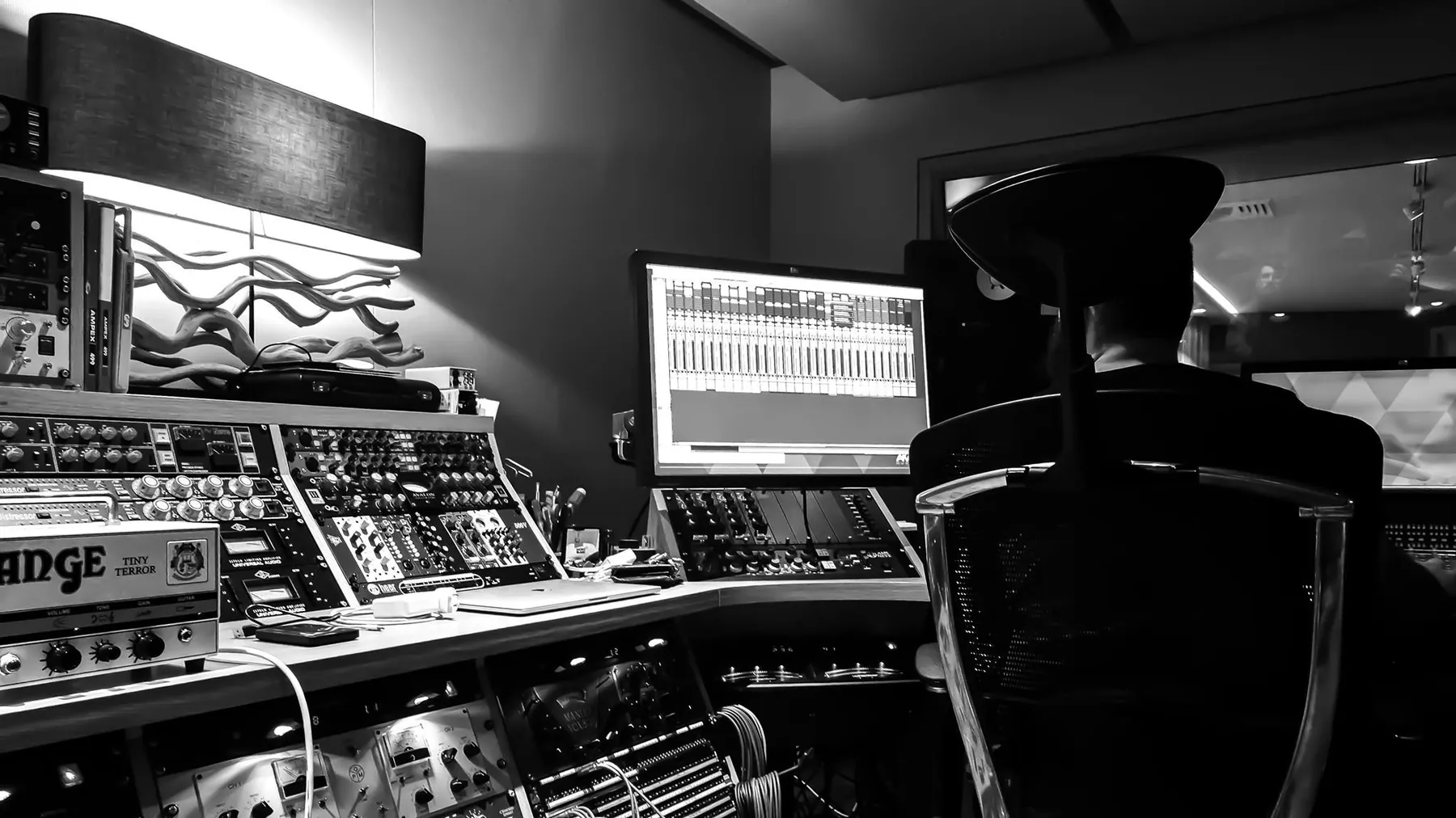 Behind the desk at A Sharp in black and white - outboard racks, DAW and the engineer's chair