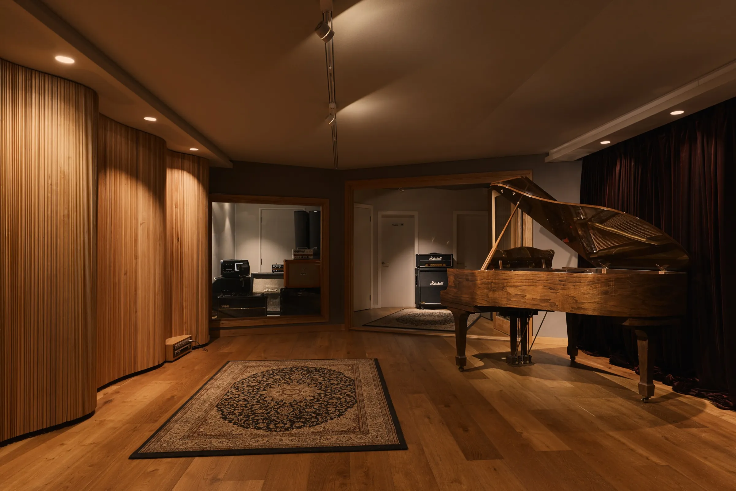 The empty A Sharp live room - timber slat walls, grand piano, Persian rug