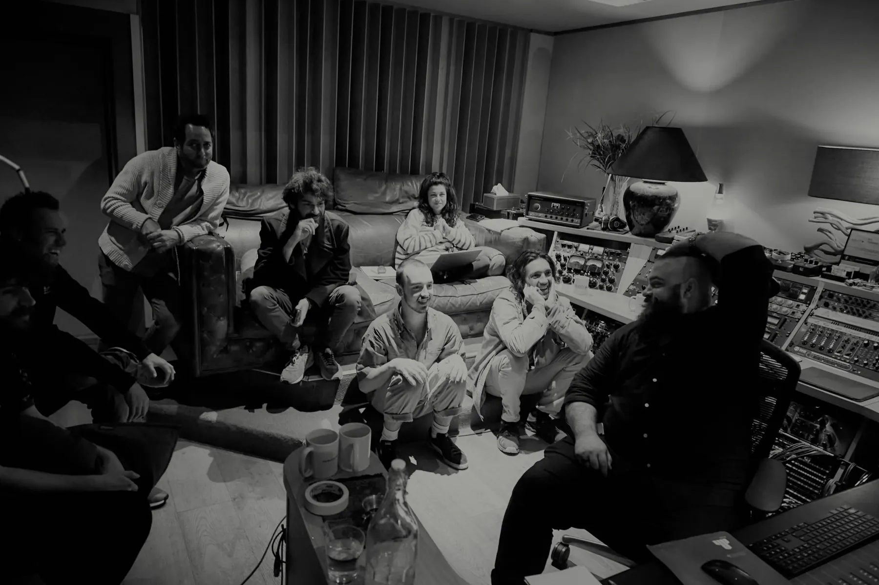 A band and engineer gathered on the lounge chesterfields for playback at A Sharp