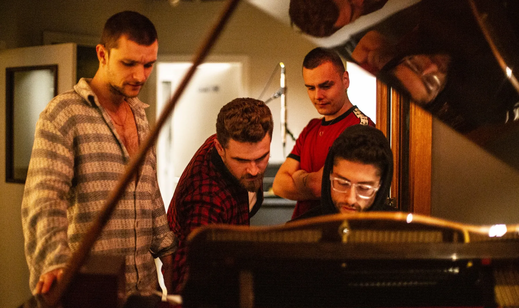 A band gathered around the open grand piano at A Sharp